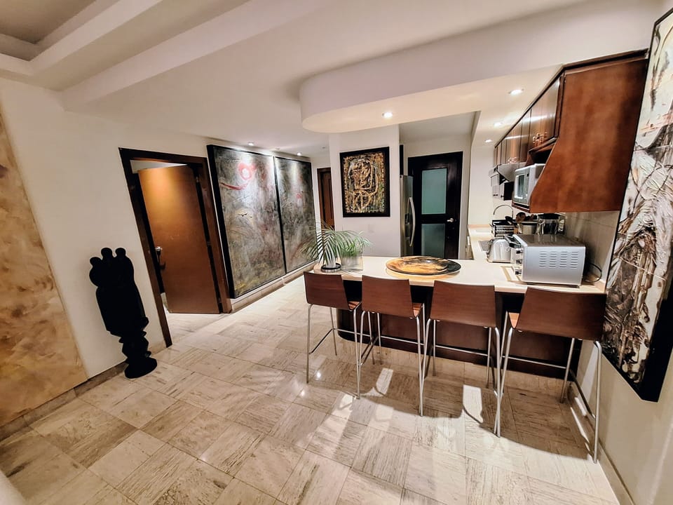 kitchen has a bar with 4 high chairs/ stools