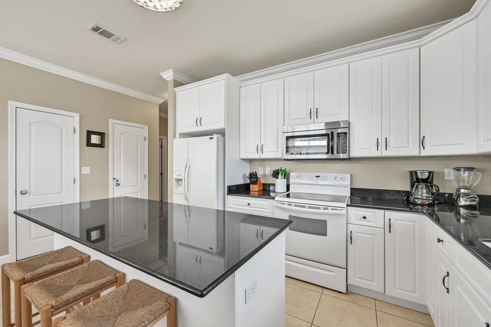 Second Floor: Kitchen – Fully stocked kitchen with an island offering extra seating for casual meals and gatherings.