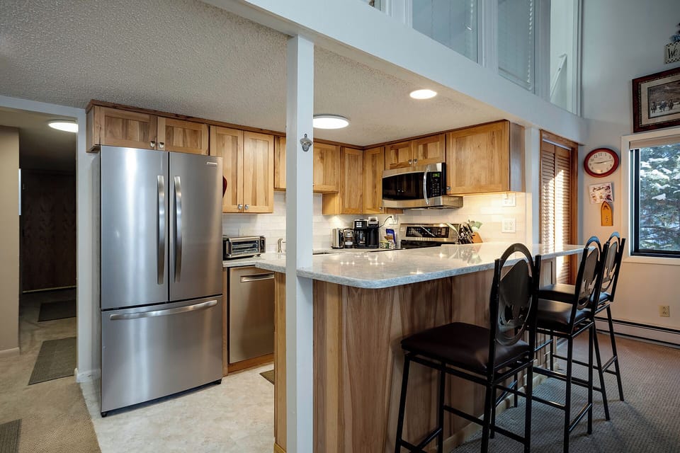 Your open-concept kitchen invites culinary adventures with granite counters, stainless appliances, and a breakfast bar perfect for morning coffee.