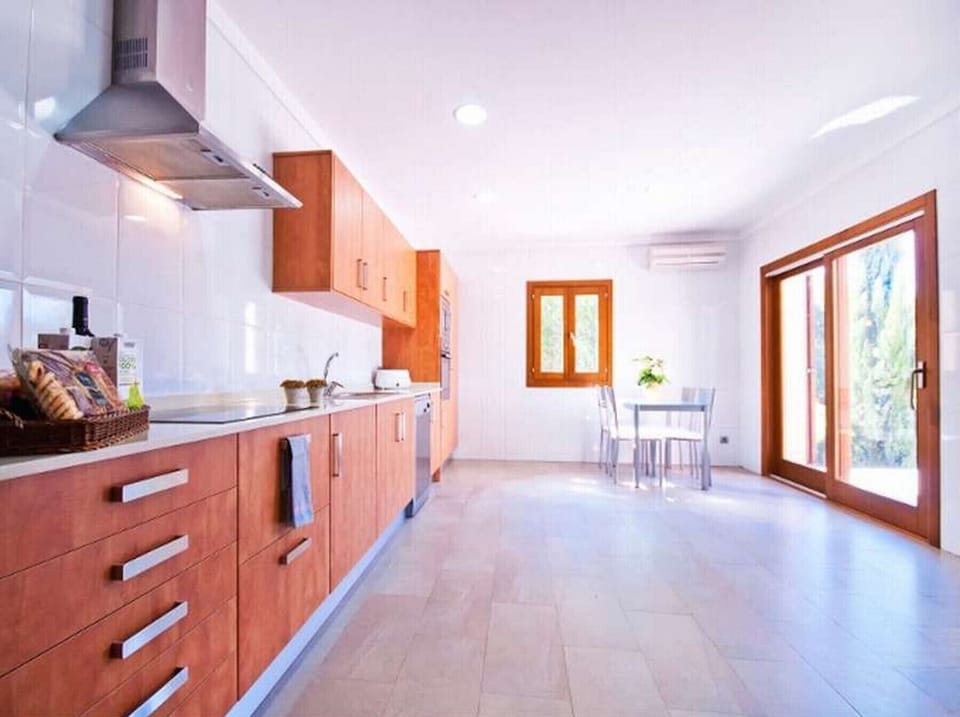 Spacious fully equipped kitchen overlooking the pool and access to the terrace