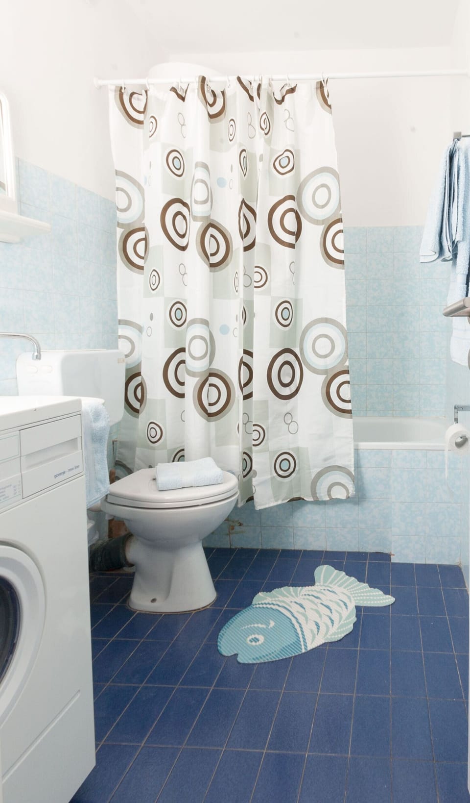 Bathroom with bath, hand held shower and washing machine