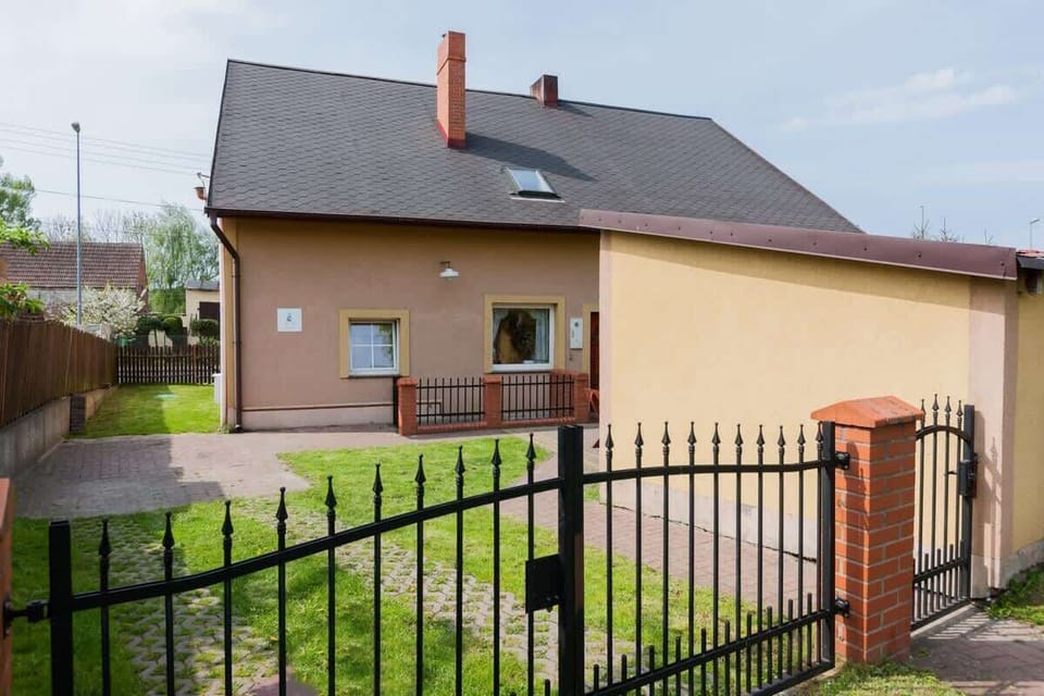 View of the house from the street. The house is enclosed by a fence. 