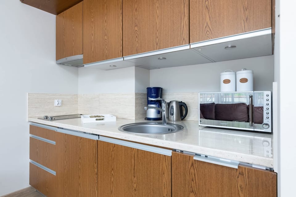 Kitchenette with microwave and coffee machine. An electric kettle stands next to it.