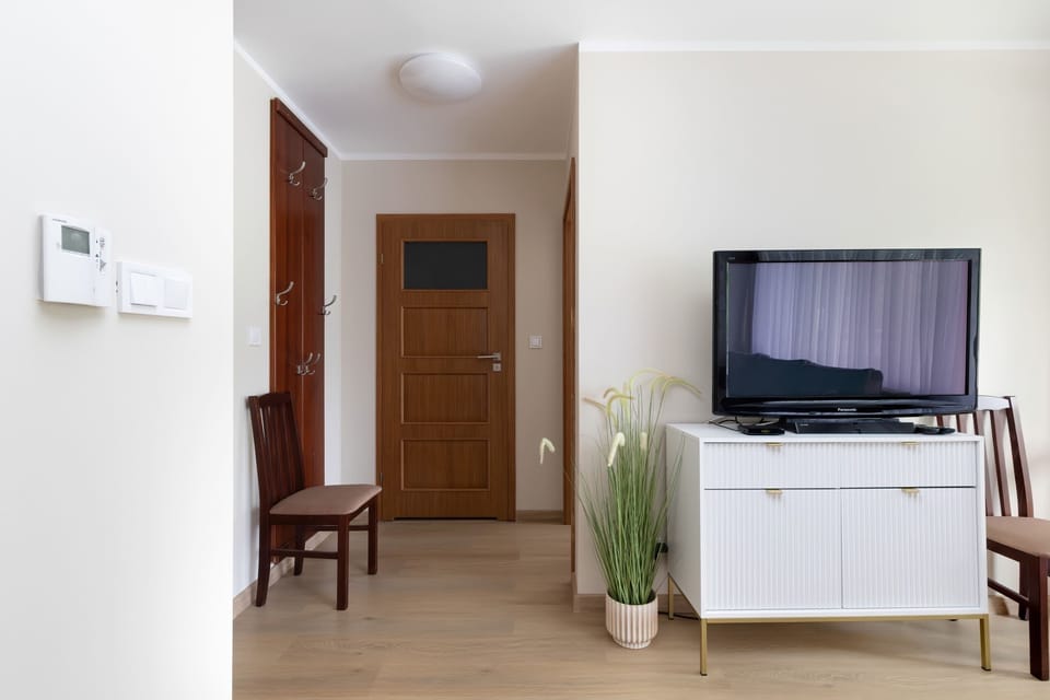 A white chest of drawers on which sits a TV that adds variety to evenings in the flat.