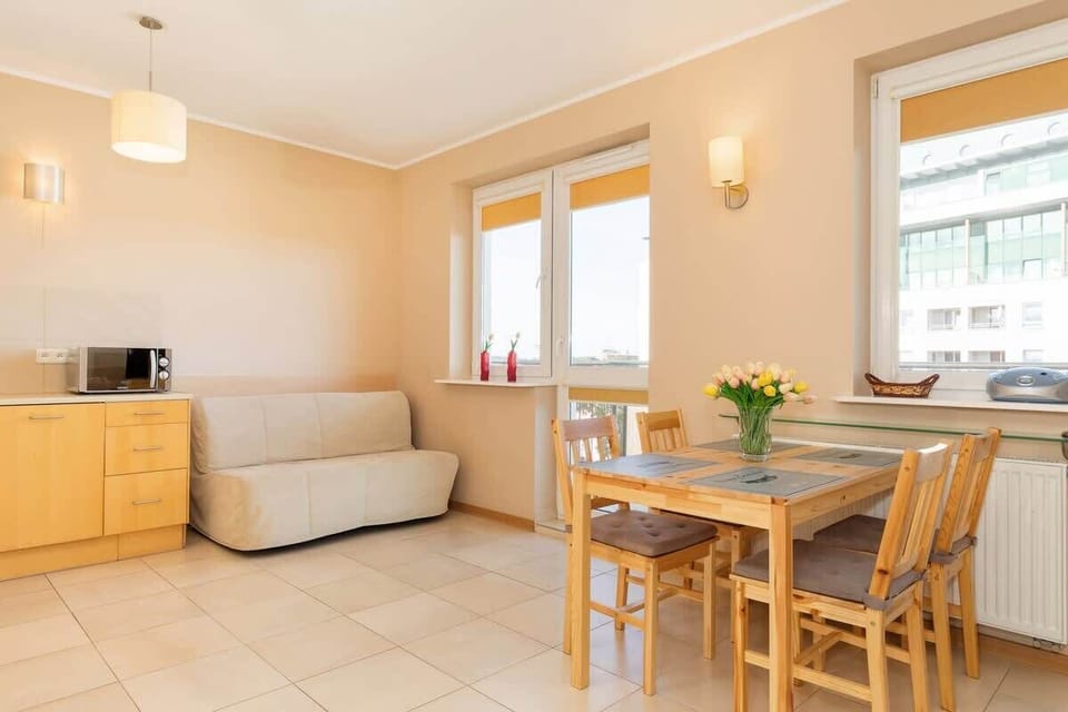 Another view of the living room with a beige sofa and table, showcasing the spaciousness of the area.