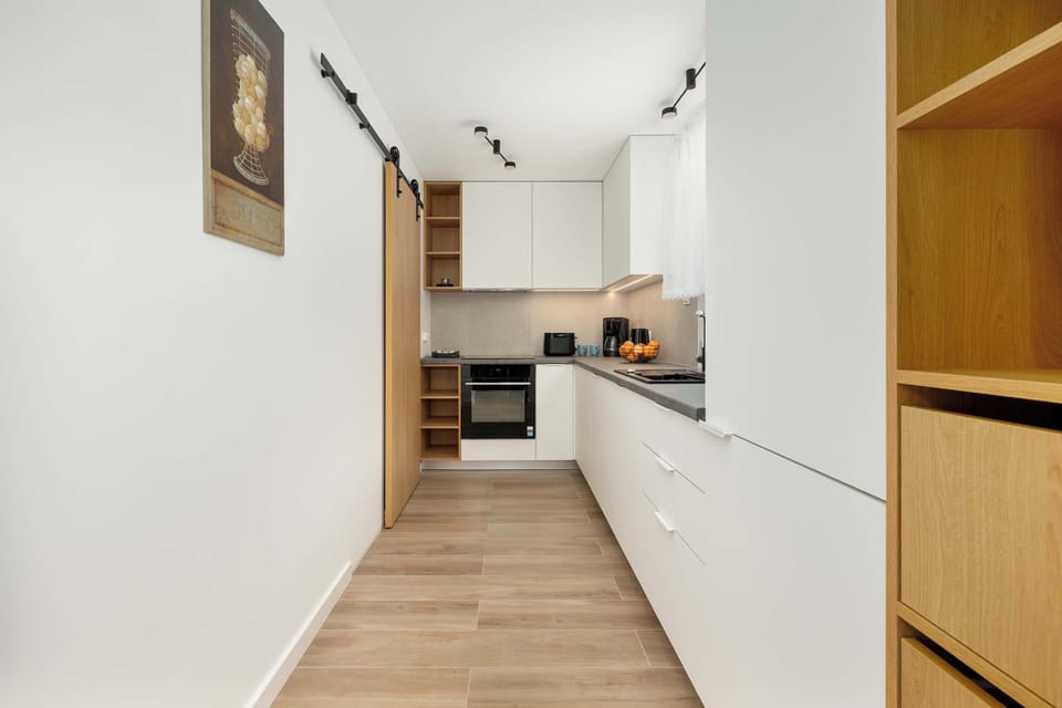 The narrow, modern kitchen equipped with appliances makes it easy to prepare any meal with comfort.