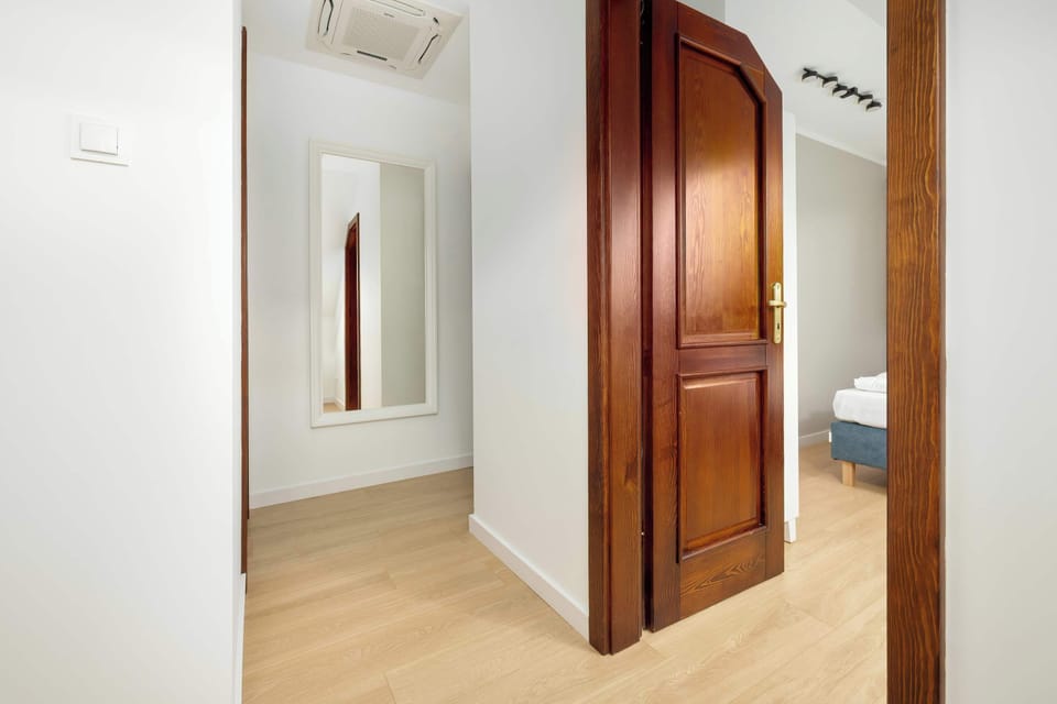 The wooden door and mirror in the hallway add elegance and emphasize the home’s classic character.