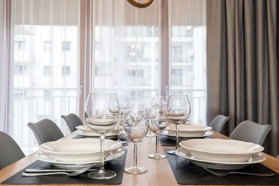 Close-up of a table with tableware. A window is visible behind the table. 