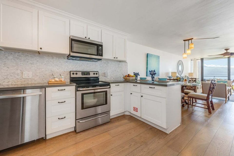 Beautifully updated kitchen with sleek countertops, white cabinetry, and open sightlines into the living and dining areas
