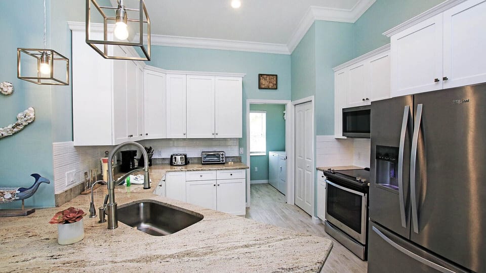 Kitchen with stainless steel appliances. Marbled tops.