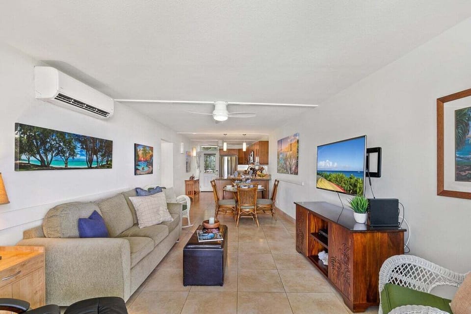 Spacious open‑concept living area featuring stylish décor, large artwork, and comfortable seating perfect for unwinding after beach days.