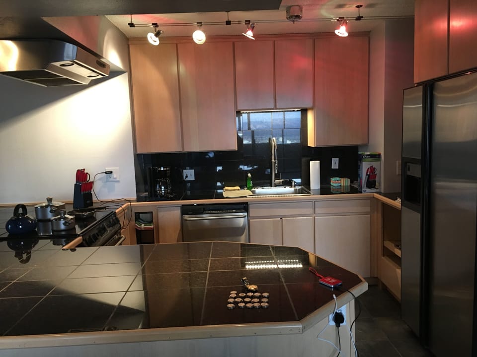 Granite counter tops with maple wood kitchen cabinets plus custom lighting