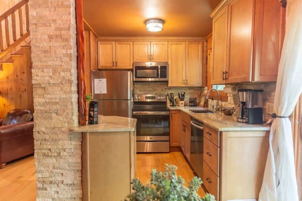 Fully equipped kitchen with stainless appliances and generous counter space, ready for group meals after a full day exploring Torch Lake and Bellaire