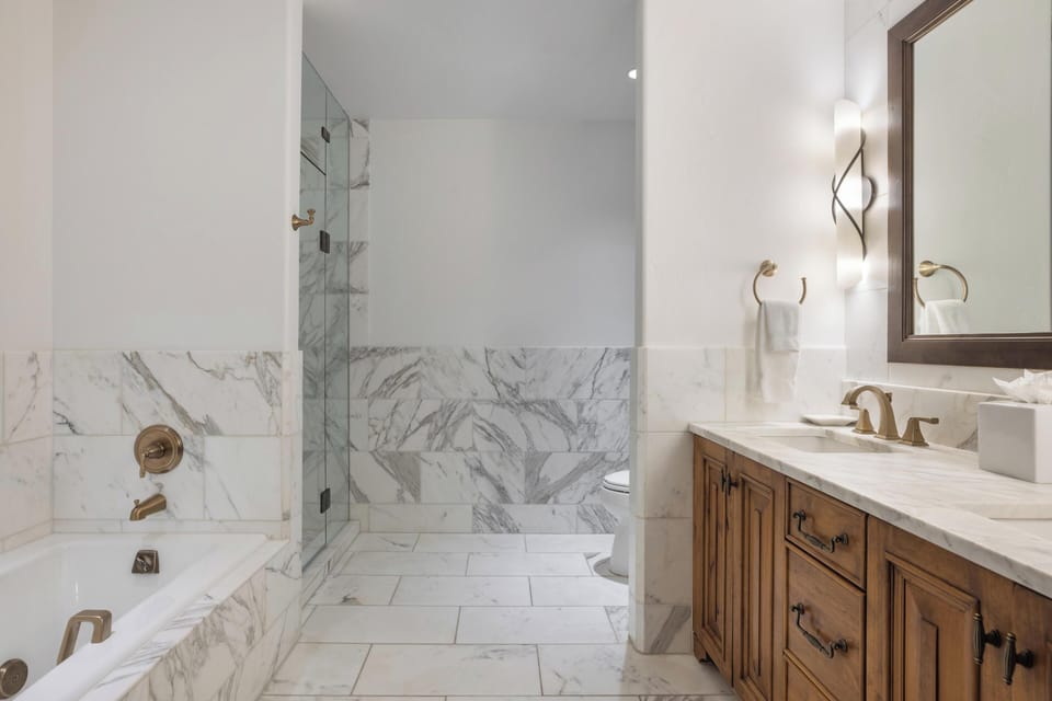 Step into your spa-inspired sanctuary, where marble elegance meets modern comfort. Unwind in the soaking tub or refresh beneath the glass-enclosed shower—your personal retreat awaits.