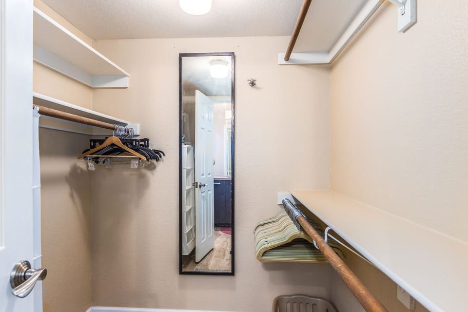 Wood print plank tile flooring flows into the master closet from the master bath.