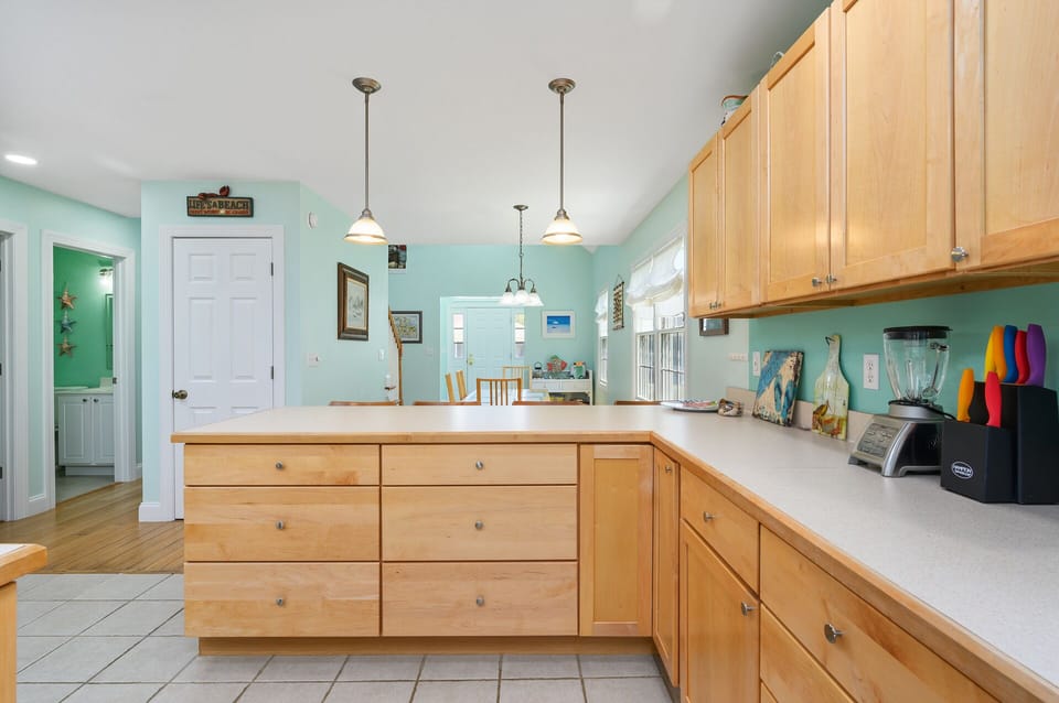 Beachy Light Wood Cabinets & Custom Tile adorn the lovely Kitchen.