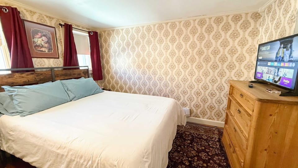 【Bedroom】TV at the foot of the bed and extra blankets in the dresser