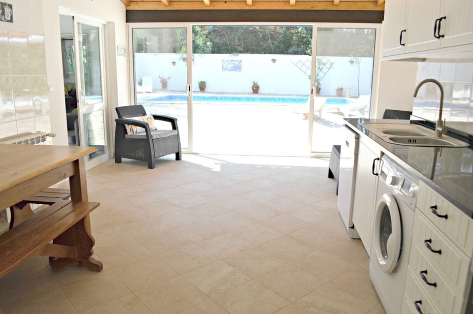 Fully fitted kitchen with full height glass doors and large farmhouse table
