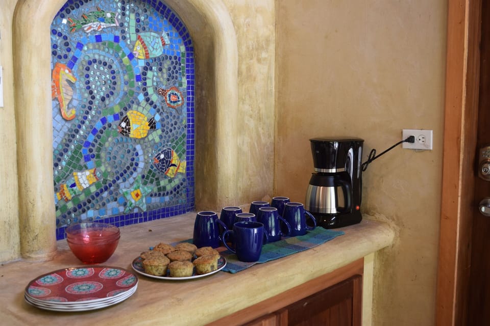 Coffee and muffins in the outside kitchen.  Mosaic made with local art.