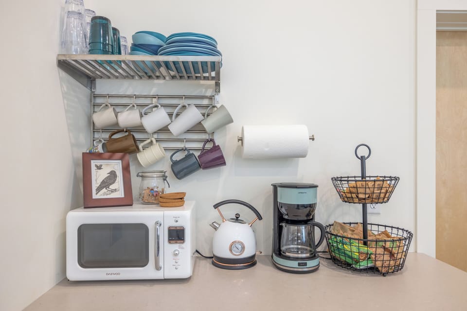 Breakfast bar with coffee, tea, oatmeal, & snacks.