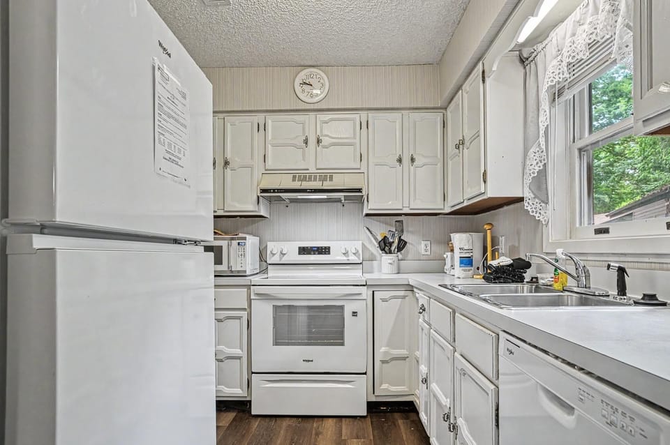 Your fully equipped kitchen offers everything needed to prepare home-cooked meals during your stay, with a full-size stove, ample counter space, and bright natural light from the window.
