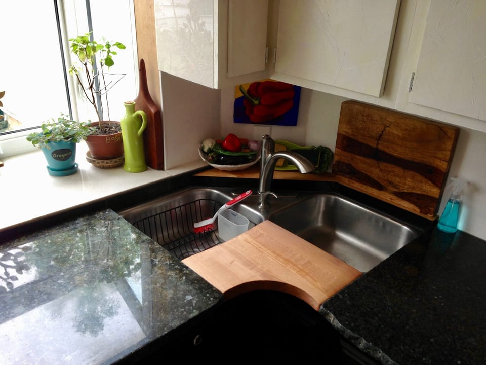 Solid granite countertops  are connected with a sculpted cutting board. 