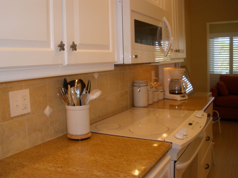 View of kitchen with granite counter, cabinets and stove