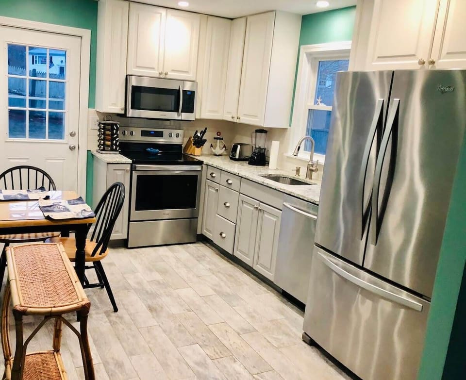 NEW kitchen with quartz counter tops, stainless steel appliances and beach-wood style tile floors.