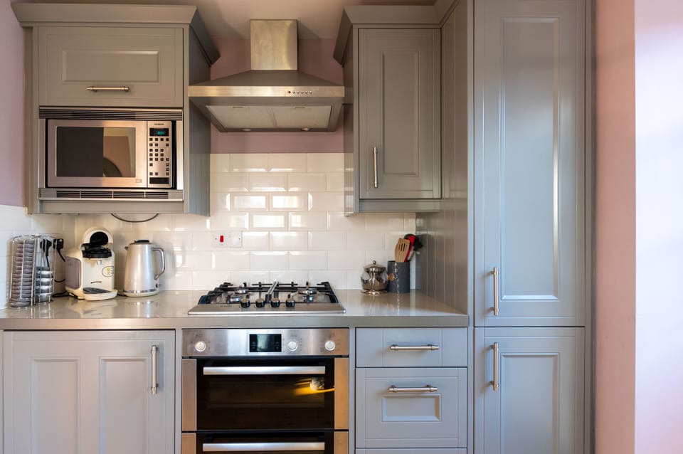 Modern fitted kitchen with four burner gas hob, fan assisted oven and microwave.