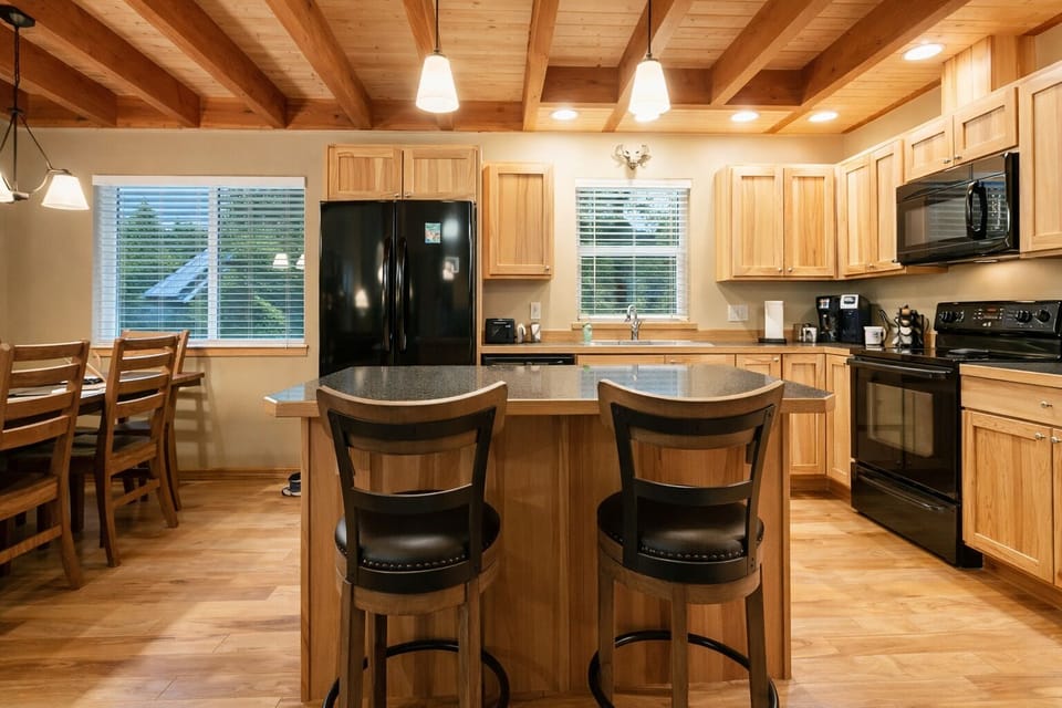 Gather around your spacious kitchen island for morning coffee or evening wine, surrounded by warm wood beams and fully equipped cooking amenities.
