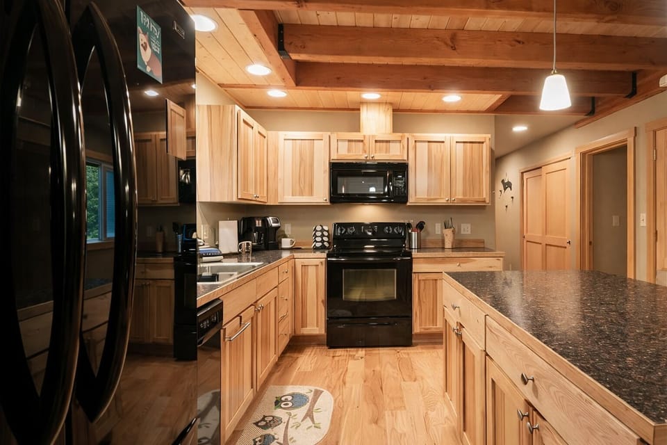Your fully-equipped gourmet kitchen features warm wood cabinetry, granite countertops, and modern appliances ready for your culinary adventures.