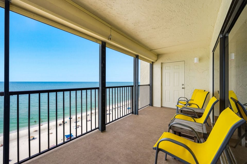 Enjoy Breathtaking Direct Gulf of Mexico Views from This Spacious Private Beachfront Condo Balcony, Featuring Comfortable Outdoor Seating, Bright Yellow Lounge Chairs, and Panoramic Ocean Views