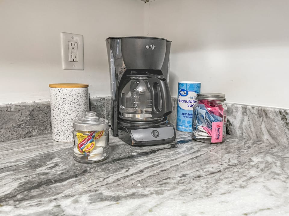 Drip coffee maker with coffee and condiments provided
