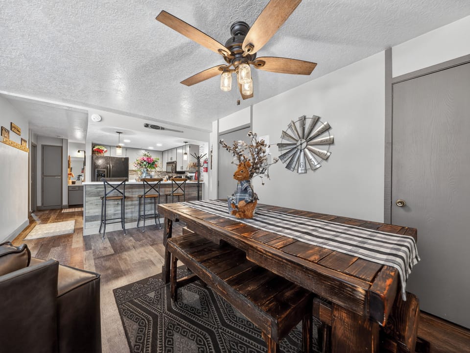 Step into your rustic-chic dining room where farmhouse charm meets modern comfort. The vintage ceiling fan adds gentle comfort above your farmhouse table.