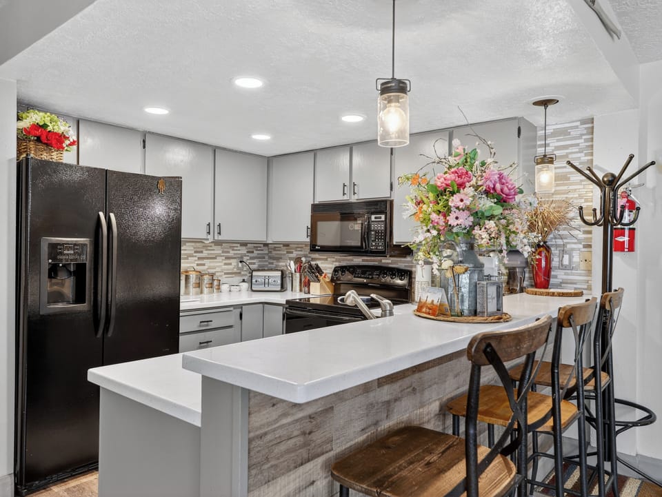 Your modern kitchen awaits with sleek appliances, island seating, and warm pendant lighting for memorable cooking experiences.