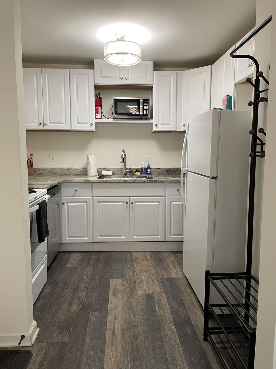 Kitchen with full-sized refrigerator, oven, cooktop, and microwave.