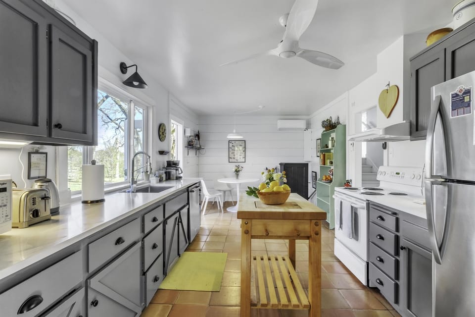 The kitchen has a small seating area and a door to the outside deck and patio.