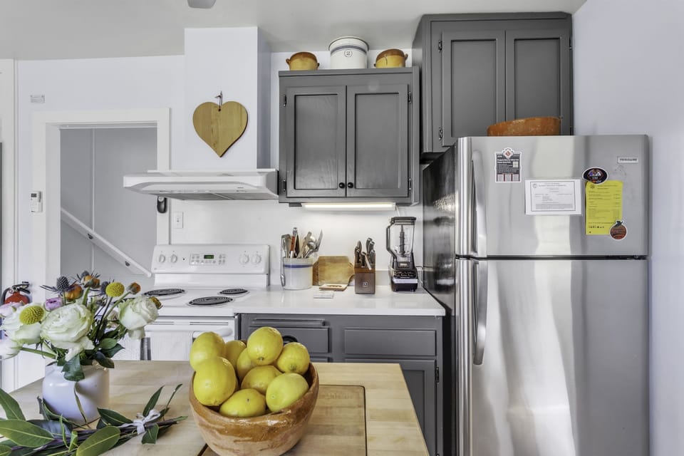 Kitchen with butcher block island and lots of cooking tools.