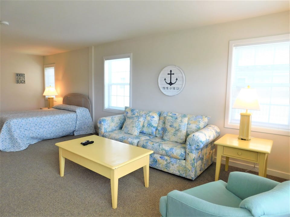 7 South Carolina Avenue - Sitting Room in bedroom - A dedicated view of the sitting room portion, showcasing the sofa, coffee table, and an armchair by the windows.