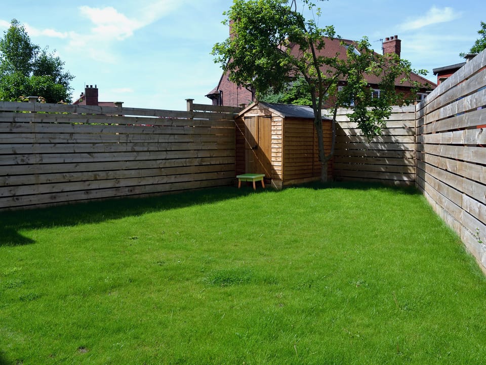 Enclosed lawned garden with patio and garden furniture | Apple Tree House, Scarborough