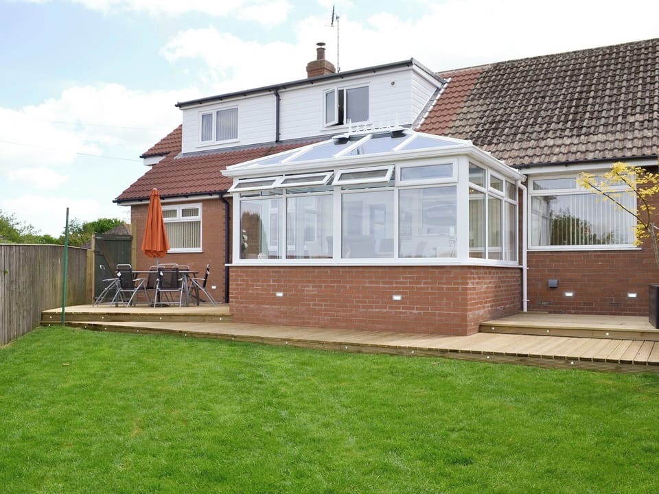 Rear of property with outdoor furniture and decked patios | The Retreat, Hunmanby, near Filey