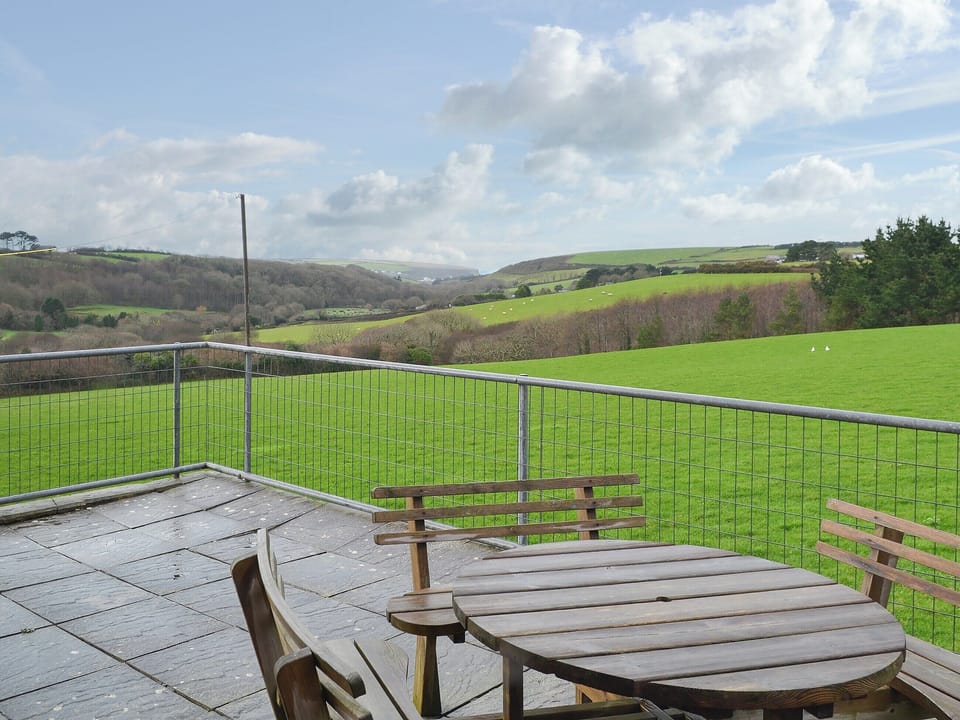Paved patio with table and chairs to admire the landscape | Porth View - Higher Lanvean Farm, St Mawgan, near Newquay