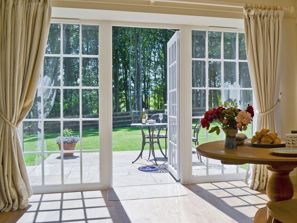 French doors from the dining area leading onto the patio | Curlew Cottage - Strathisla Farm Cottages, Meigle