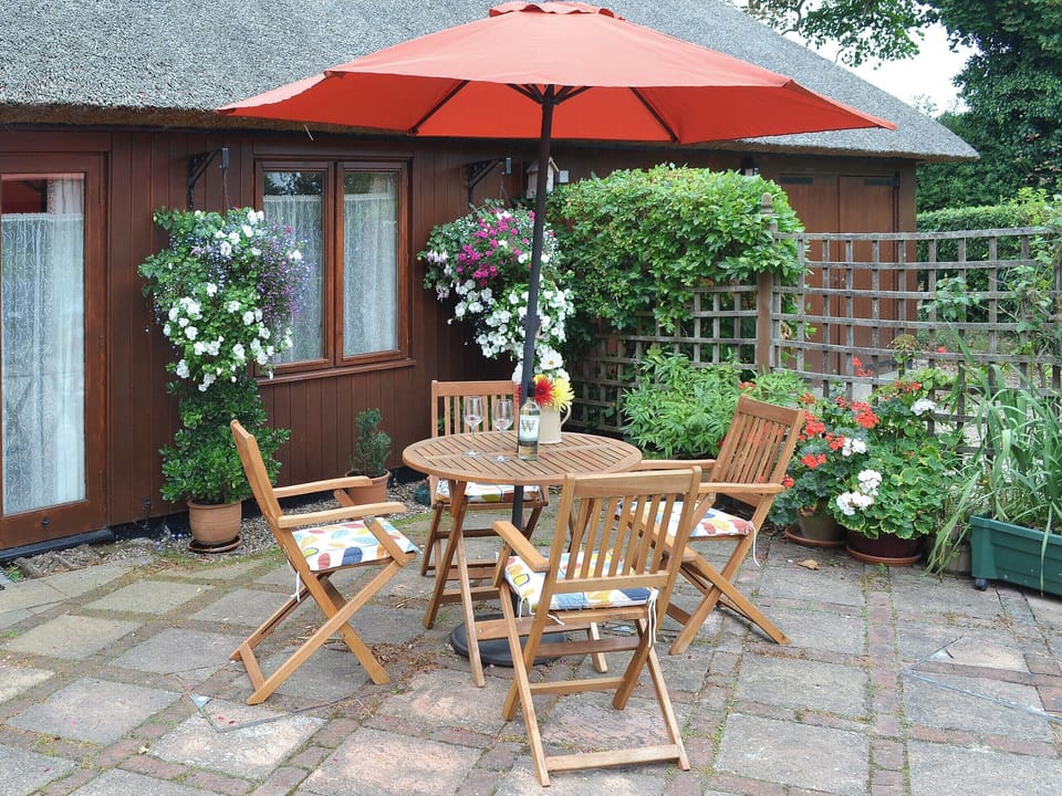 The paved area has a table and chairs for alfresco dining options | Church Farm Studio, Surlingham