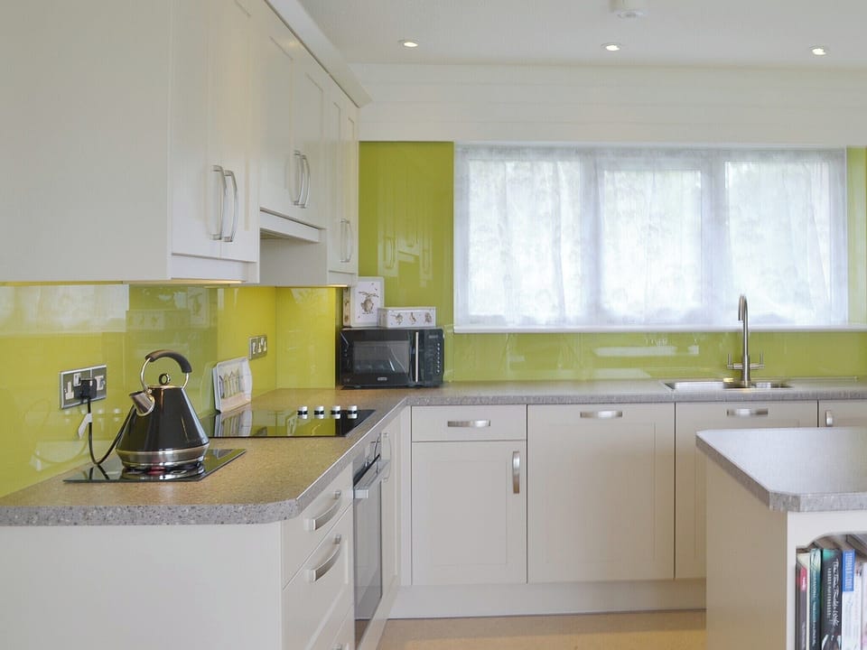 A contemporary style kitchen has a centre island and wine chiller | Tamar Ten, St Ann&rsquo;s Chapel, near Callington