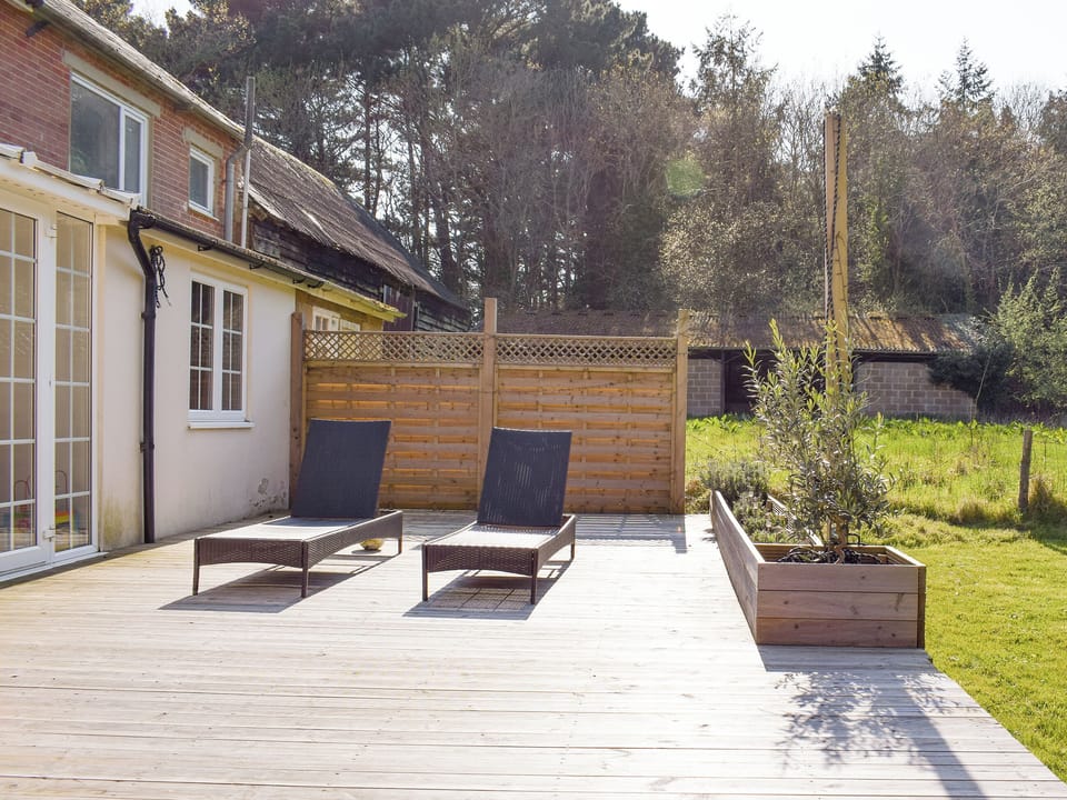 Spacious decked area overlooking garden | Pigeon Coo Farmhouse, Hamstead, near Yarmouth