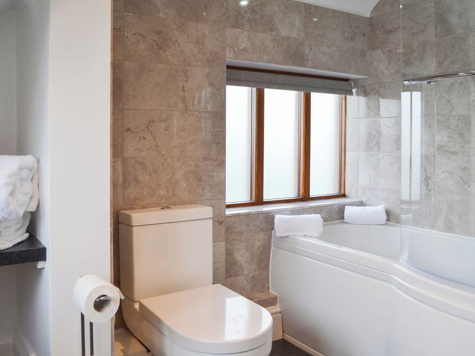 Tiled bathroom with shower over the bath | Windmill Barn, Windmill Hill, near Hailsham