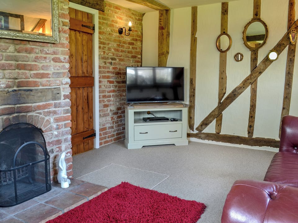 Characterful living room with open fire and beams | The Old Stables - Burfields Farm, Botesdale, near Diss