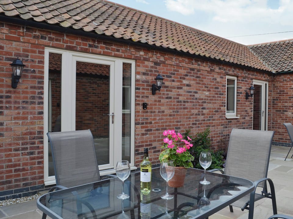Stylish contemporary table and chairs in a courtyard setting | The Old Dairy - Dunstall Lodge Barns, Sutton-on-Trent