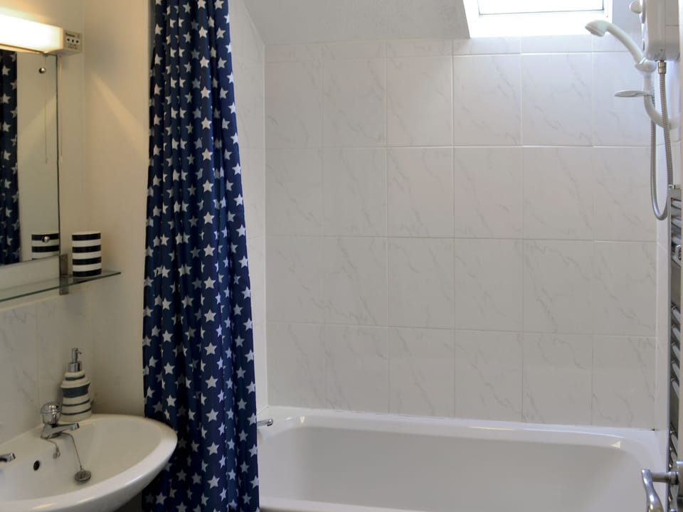 Bathroom with shower over bath and heated towel rail | Pottergate Cottage, Wroxham
